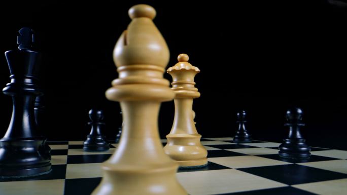 在国际象棋比赛中，DS男子用黑色的手拿着白色的皇后