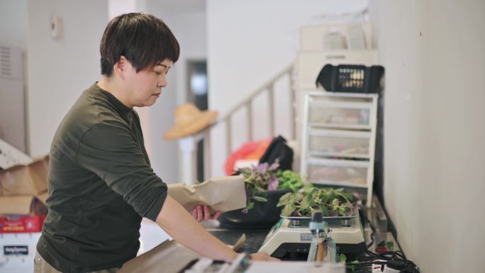 中国亚裔女商人正在称重包装立式花园的新鲜冲绳菠菜，准备出售