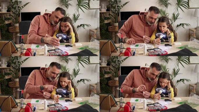 一位父亲正在教他的女儿如何制造机器人。