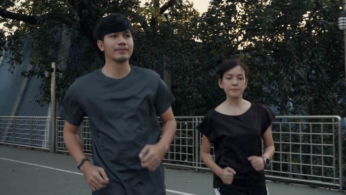 一对亚洲夫妇在城市里奔跑。