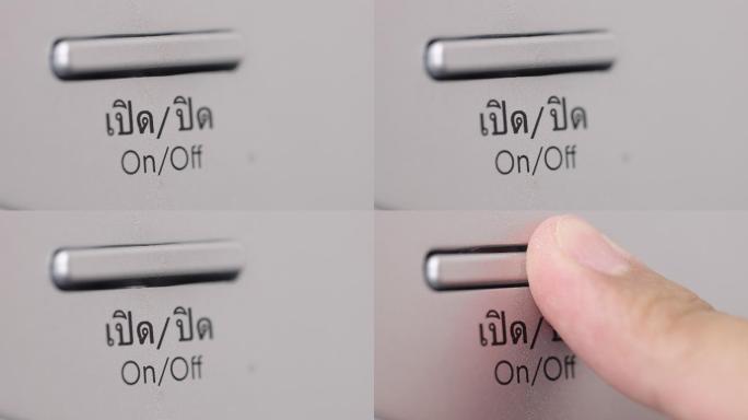泰语洗衣机上手指按下打开/关闭按钮的侧视图