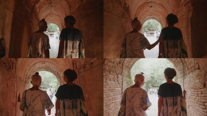 从古老的隧道庙Wat Umong（隧道庙）走出的两位活跃的资深朋友的扎染后视图。