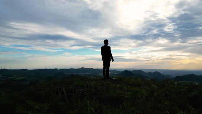 成功人士山顶张开双臂拥抱未来眺望远方梦想