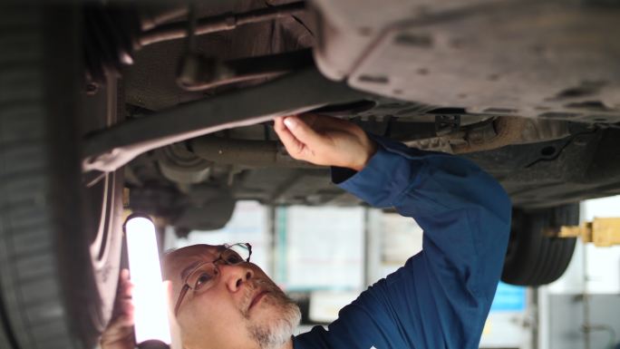 小型企业汽车服务所有者在车库检查汽车
