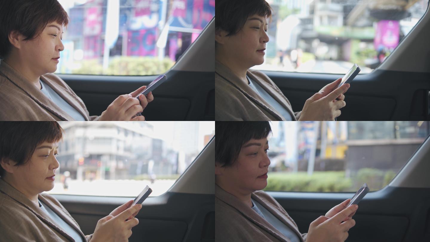 一名中国亚裔女子在豪华MPV出租车后座检查她的便携式设备