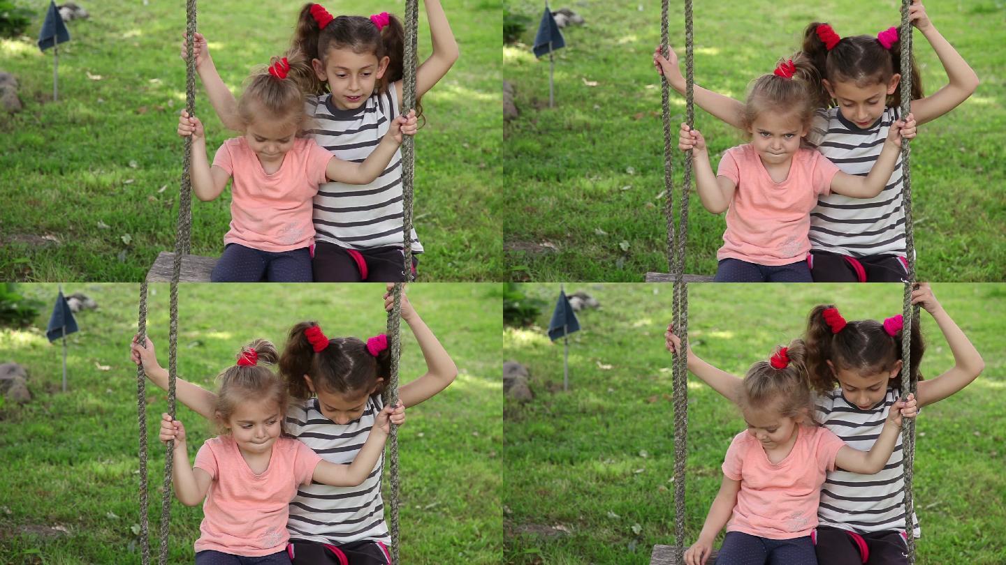 两个害羞的小女孩在后院的绳子秋千上荡秋千