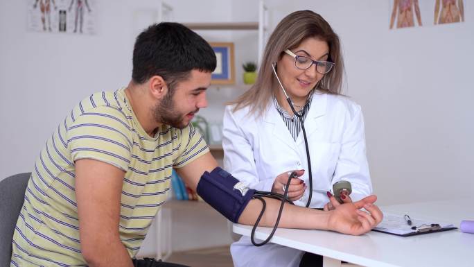 医生测量年轻病人的血压
