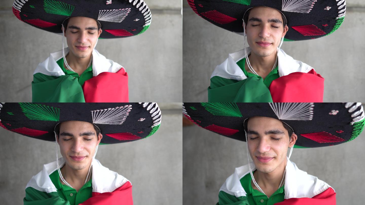 一个十几岁的拉丁男孩举着墨西哥国旗，头戴草帽
