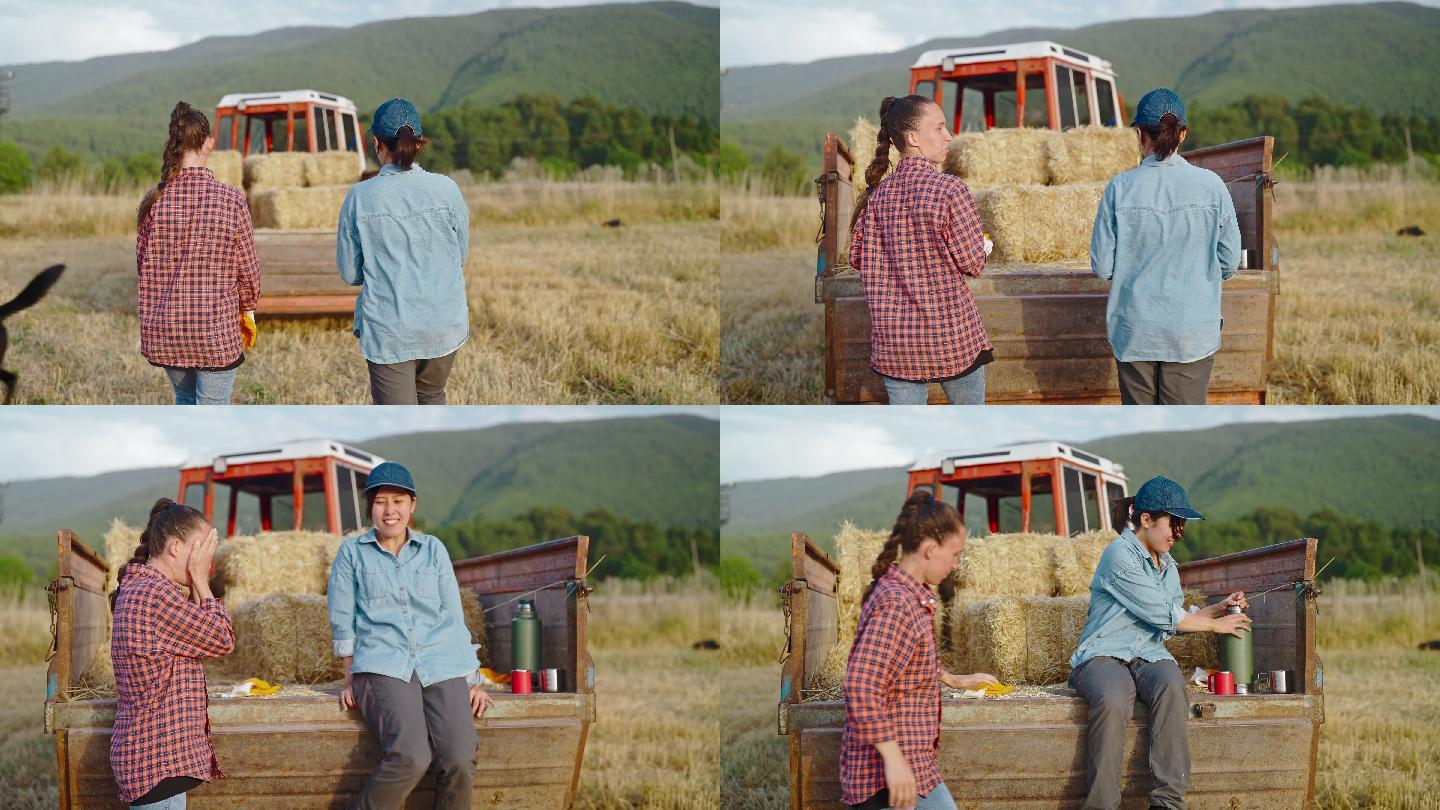 两名女农民在农场休息，在拖拉机拖车上休息，并互相交谈