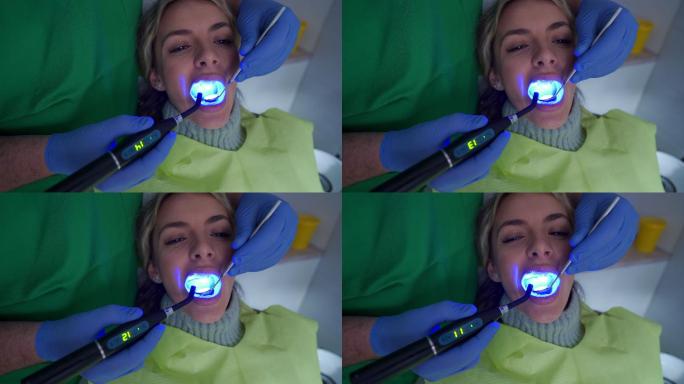 牙科医生使用紫外线灯硬化牙齿填充物