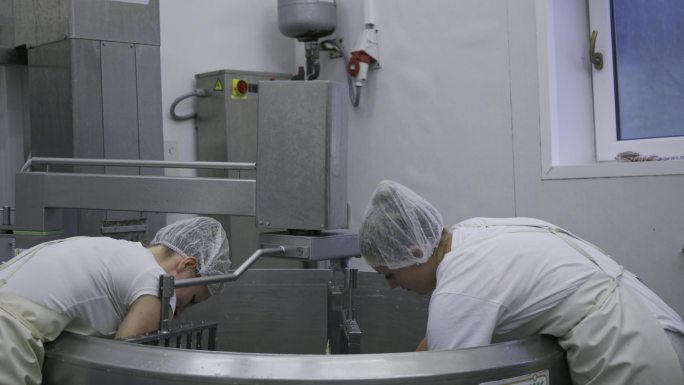 一天结束时，女工在乳品厂清洗机器