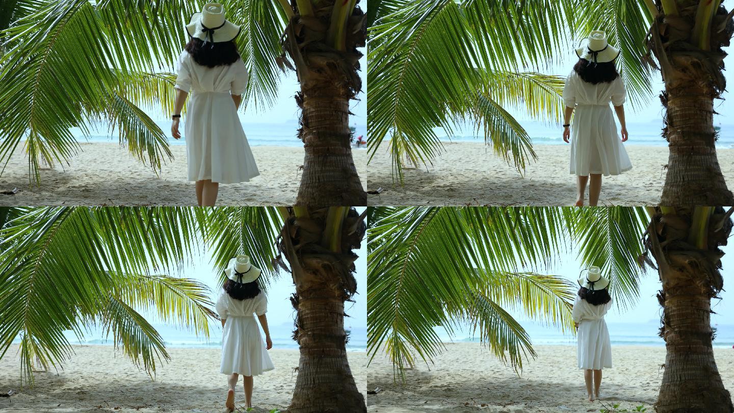 海滩上椰子树下走向大海的女人