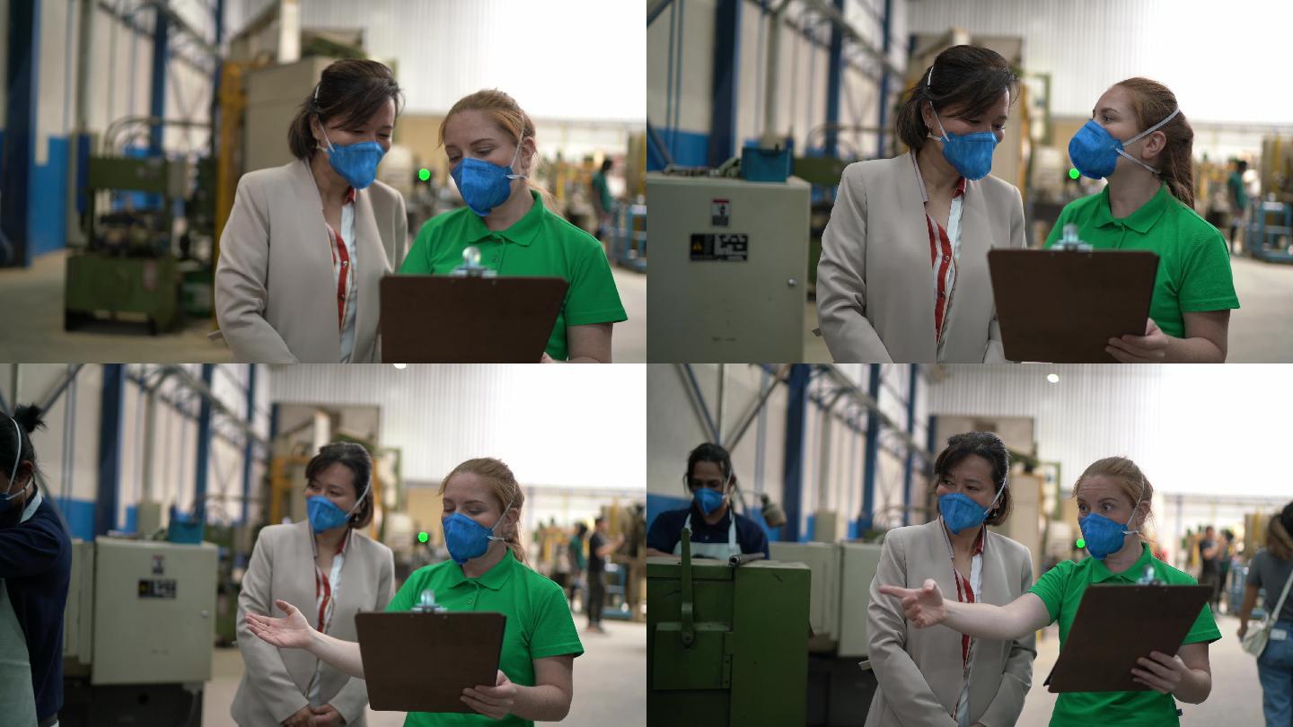 同事在工厂走路和说话-戴口罩