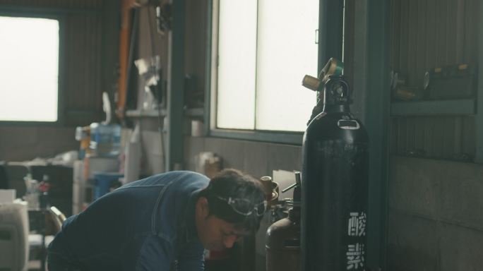 MS SLO MO-将焊炬线连接到氧气罐的焊工