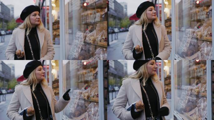 在巴黎橱窗购物时，一位魅力四射的法国女子拿着法式面包