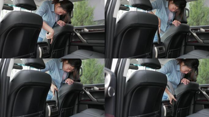 亚洲年轻女子用真空吸尘器清洁汽车