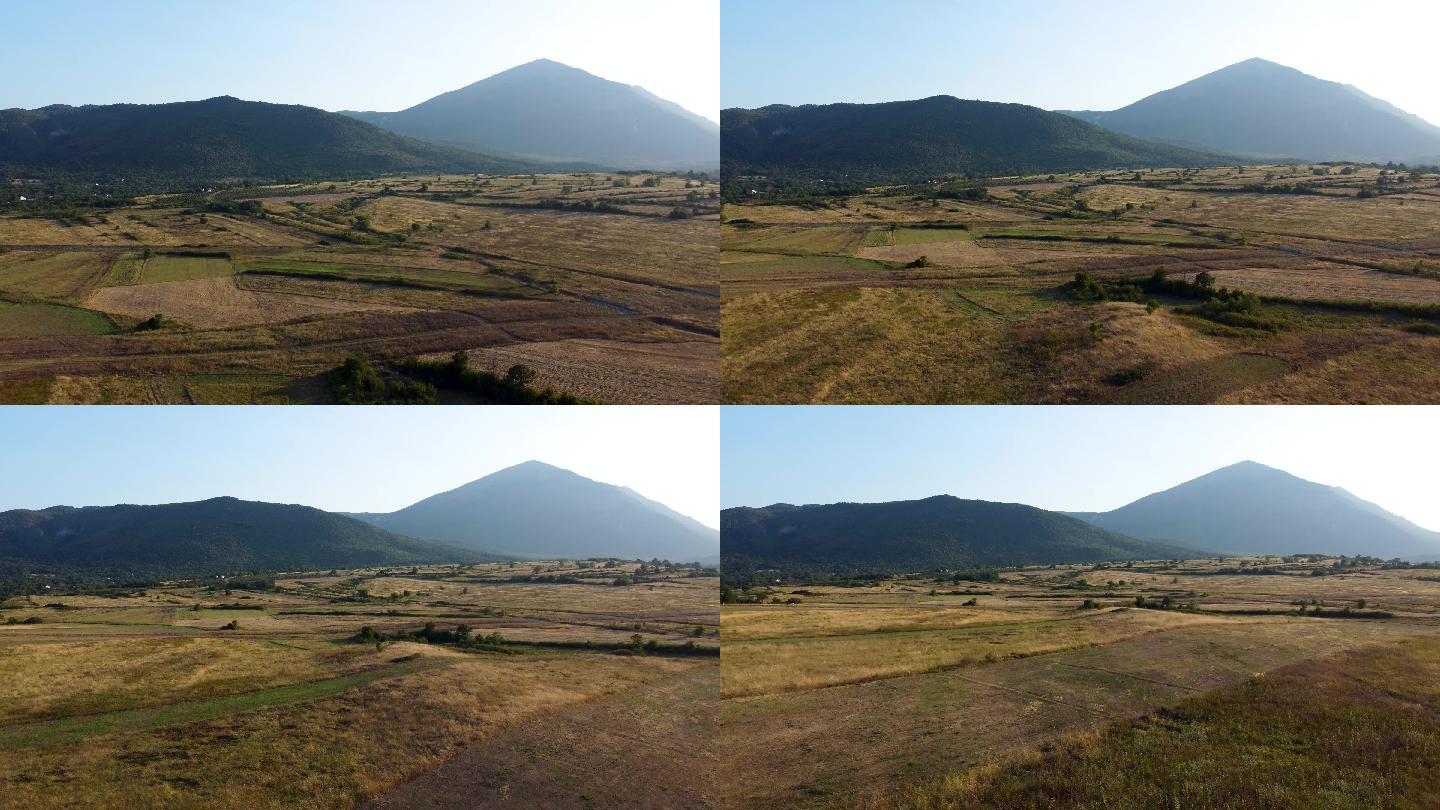日落时，在金色阳光的照射下，向后飞行穿过草地，朝着塞尔维亚东部的塔尼杰山（Rtanj mountai