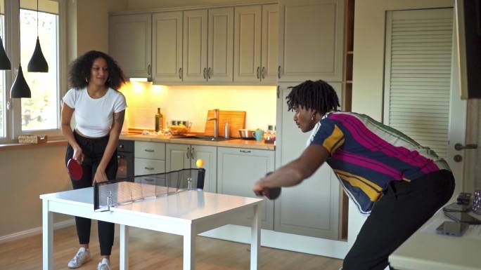 非洲裔美国年轻夫妇在家打乒乓球
