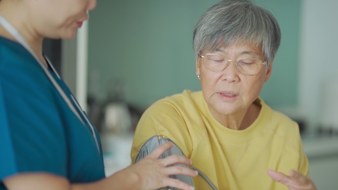 女看护在家测量老年女性血压