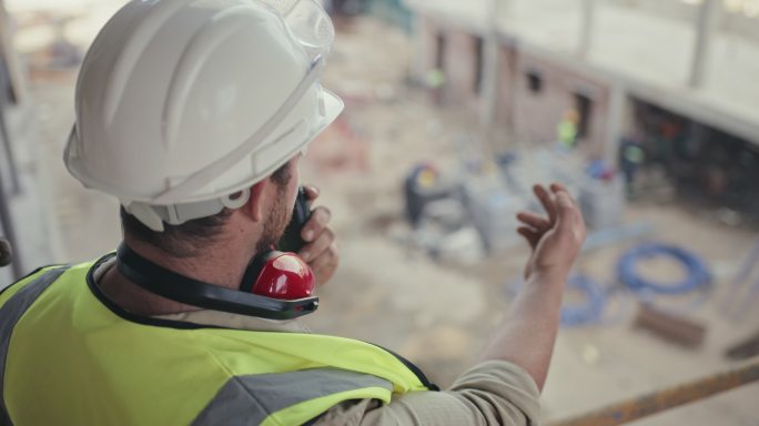 建筑承包商在施工现场工作时使用双向无线电的4k视频片段