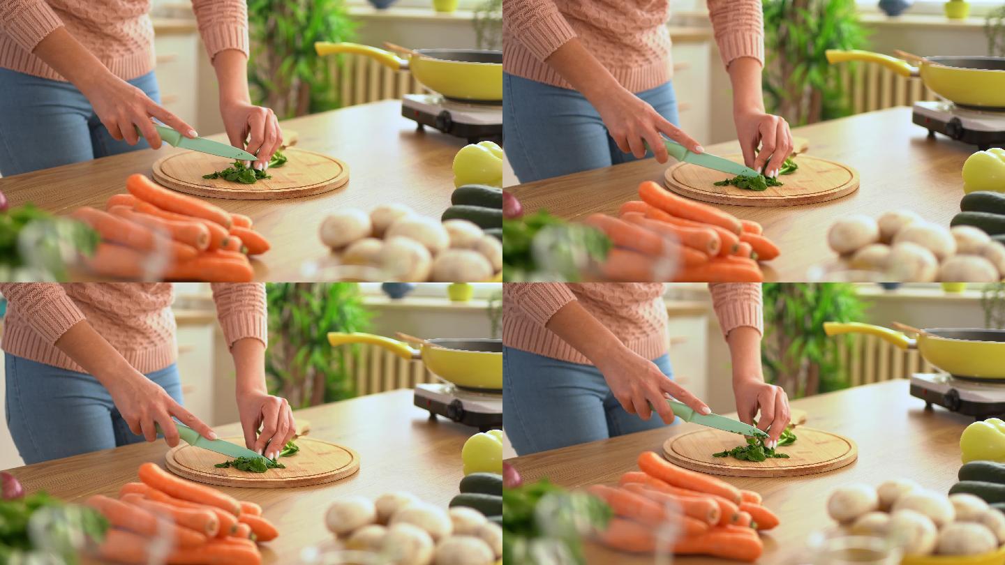 年轻女子在砧板上切菠菜
