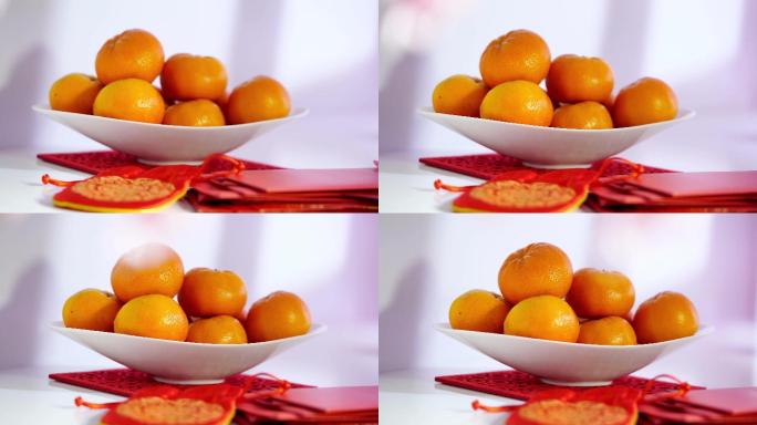 一碗橘子和红色幸运袋作为中国新年的装饰元素。