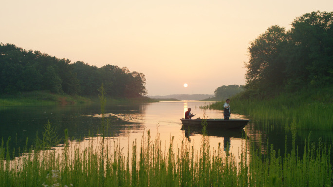 夕阳下的鱼塘渔船野生池塘