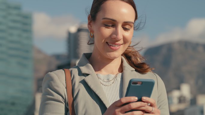 一名女商人在城市中行走时使用手机的4k视频片段
