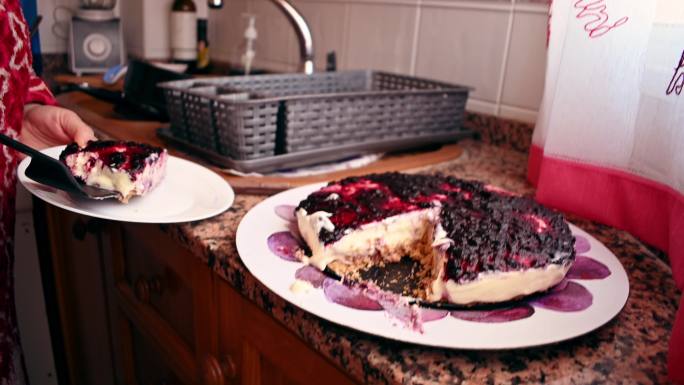 特写镜头：一名女子打破并将一块芝士蛋糕放在盘子上
