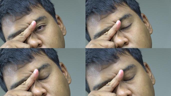 那个人用手指蹭眼睛。缓解长期使用眼睛后的眼睛疲劳。