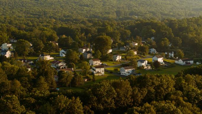 傍晚，宾夕法尼亚州波科诺斯阿巴拉契亚山脉一个小乡村小镇的远景。许多家庭的屋顶都安装了太阳能电池板。带