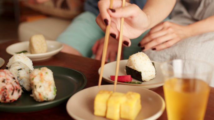 一对年轻夫妇在家吃日本饭团的特写镜头