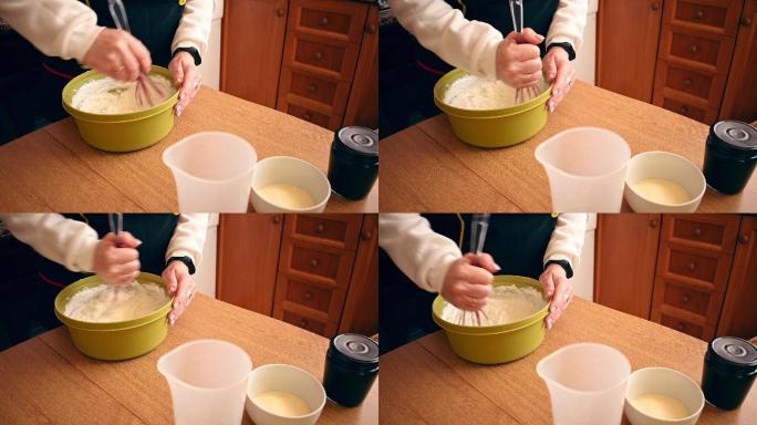 一个女人在碗里搅拌奶油制作奶酪蛋糕的特写镜头