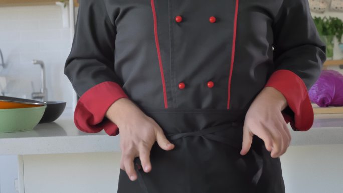 专业厨师将围裙系在腰间的正面图