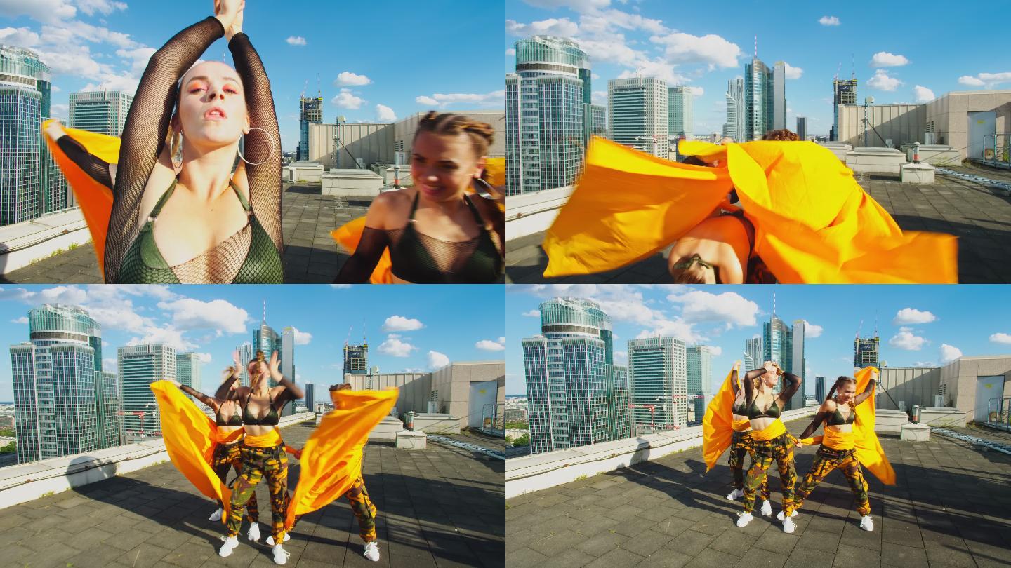 身着迷彩服的女性舞者在屋顶上表演。躲在橙色织物后面