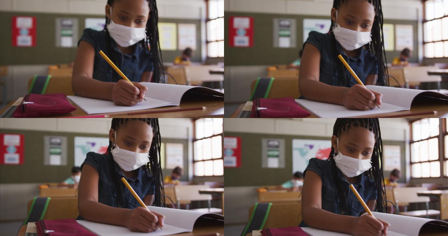 戴着口罩的女孩坐在她的课桌上写字