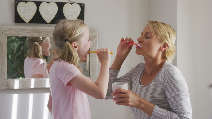 一个白人妇女和她的女儿正在刷牙