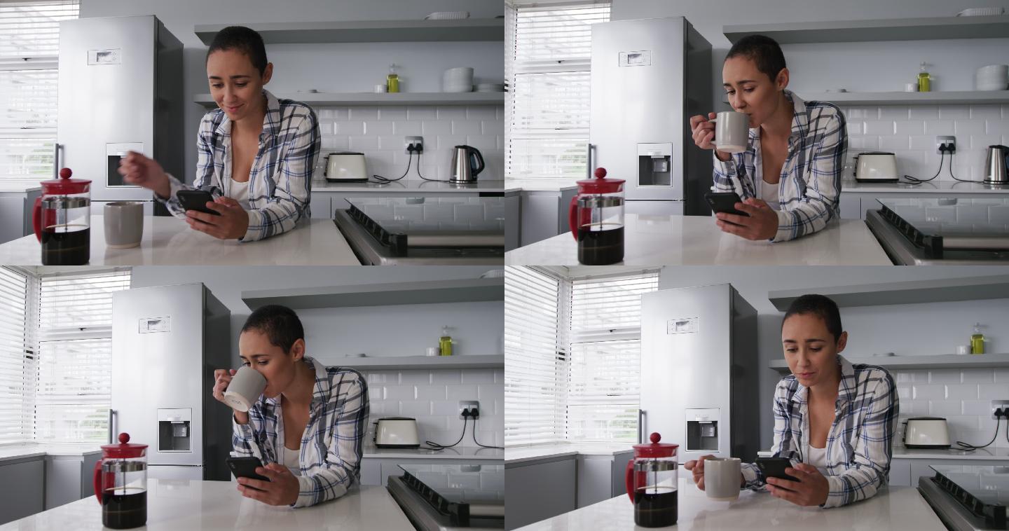 一个女人在厨房用智能手机喝咖啡
