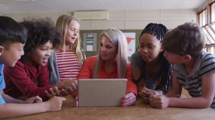 女老师和一群在课堂上使用笔记本电脑的孩子