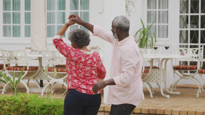 一对高级非裔美国人在花园跳舞以保持社交距离