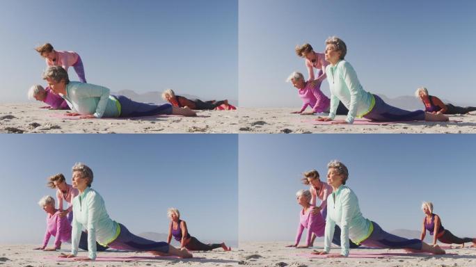 瑜伽老师在海滩上教高级女性瑜伽