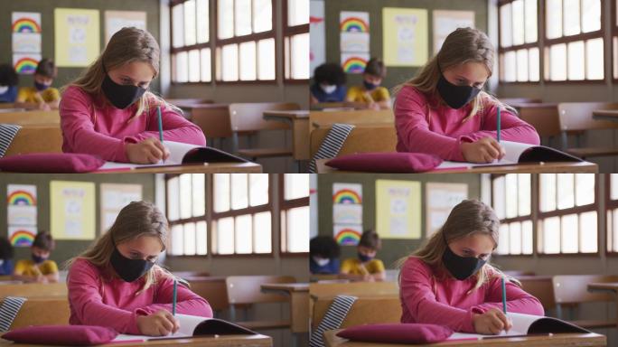 戴着口罩的女孩坐在她的课桌上写字