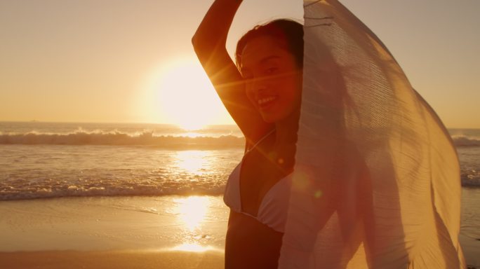 海边的年轻女子海边慢动作跑沙滩美女日光阳