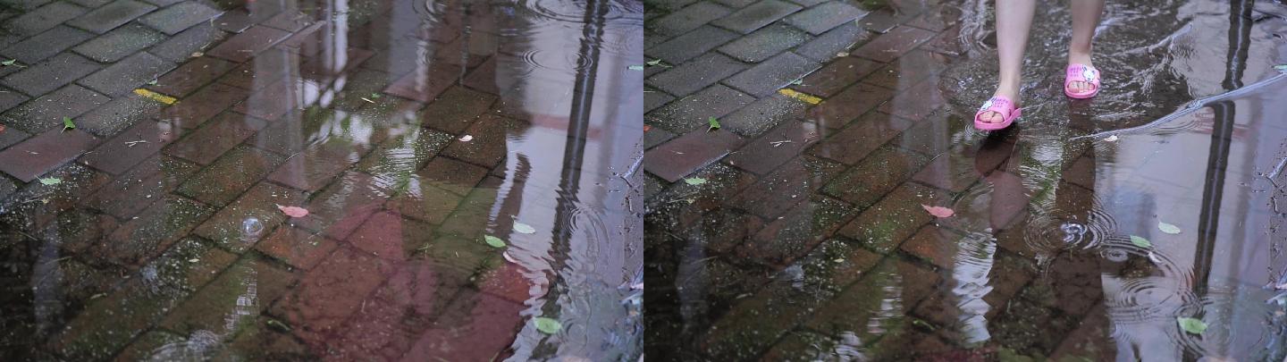 打伞的人走过雨中路面积水