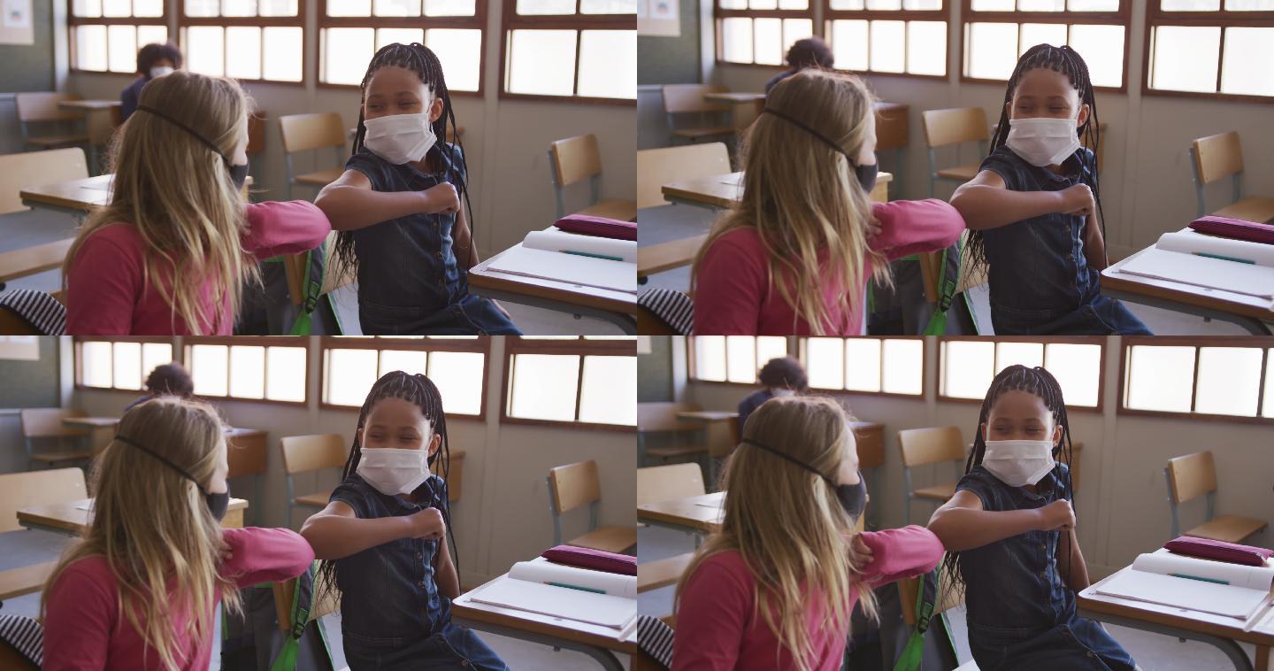 两个戴着口罩的女孩在学校用手肘触碰对方打招呼
