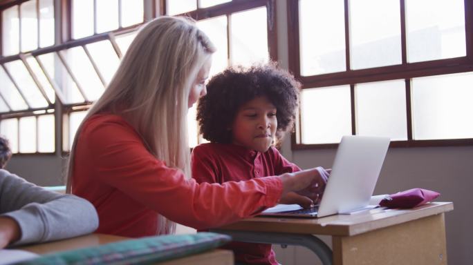 女老师和男孩在课堂上使用笔记本电脑