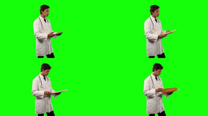 医生用绿色屏幕检查他的文件的侧视图
