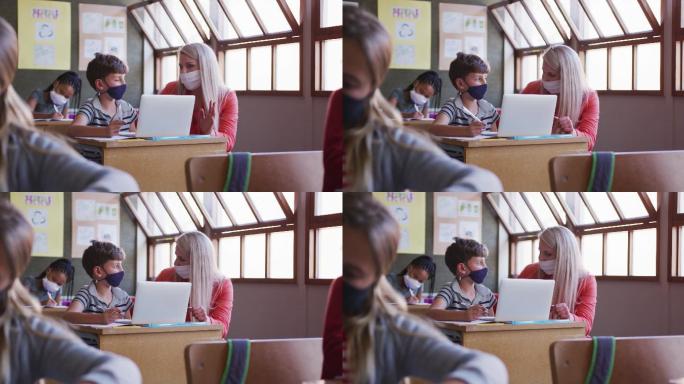 女老师和男生戴着口罩在学校上课用笔记本电脑
