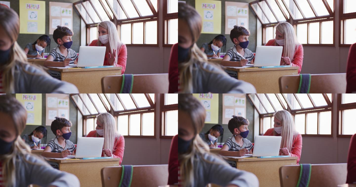 女老师和男生戴着口罩在学校上课用笔记本电脑