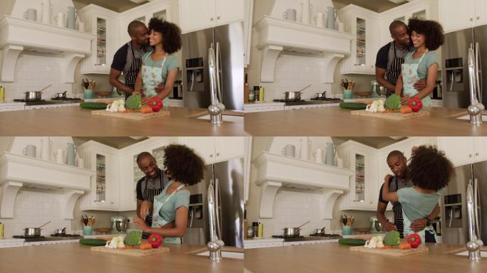 快乐的混血夫妇在他们的厨房里做饭跳舞